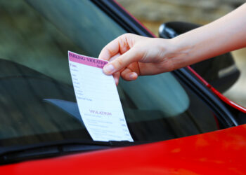 Pessoa recebendo multa por dirigir em faixa exclusiva