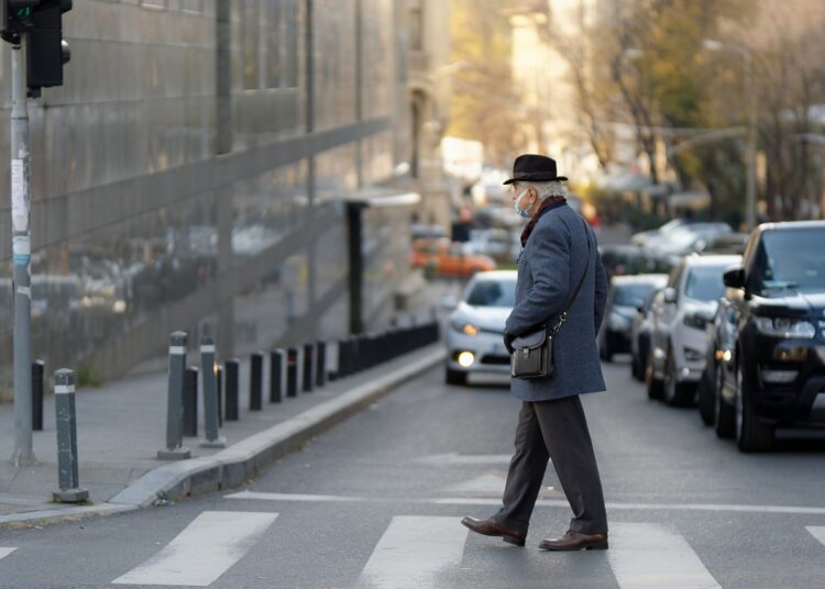 Senhor atravessando a rua e se perguntando: Qual a multa por não dar preferência ao pedestre