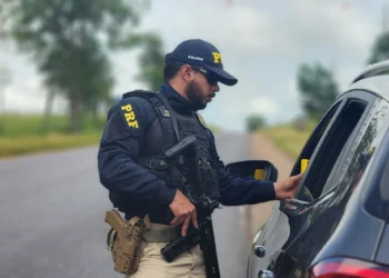 Agente da Polícia Rodoviária Federal realizando abordagem em rodovia.