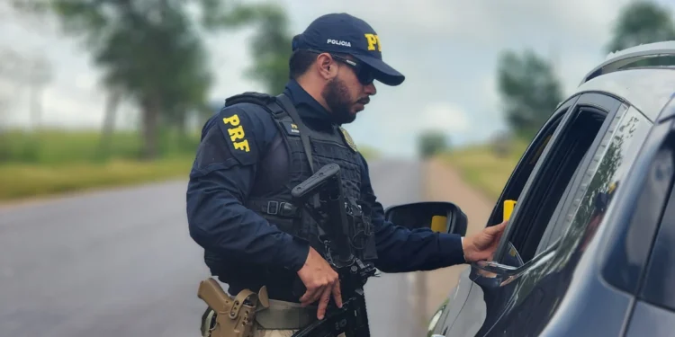 Agente da Polícia Rodoviária Federal realizando abordagem em rodovia.