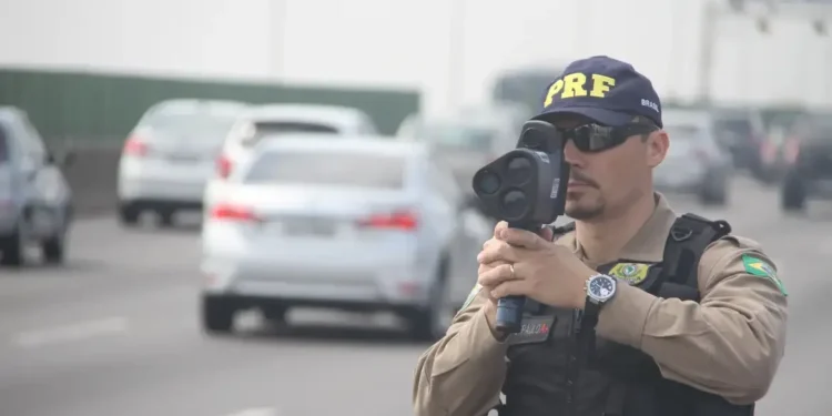 Policial medindo velocidade na estrada.