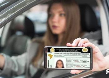 Mulher dentro do carro exibindo a CNH digital na tela do celular.