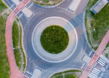 Vista aérea de uma rotatória moderna com ciclovias e faixas de pedestres integradas.