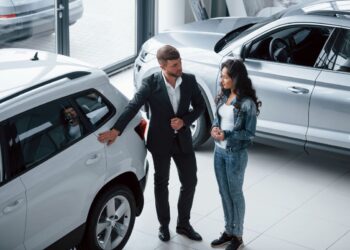 Cliente e vendedor discutindo sobre carro em concessionária