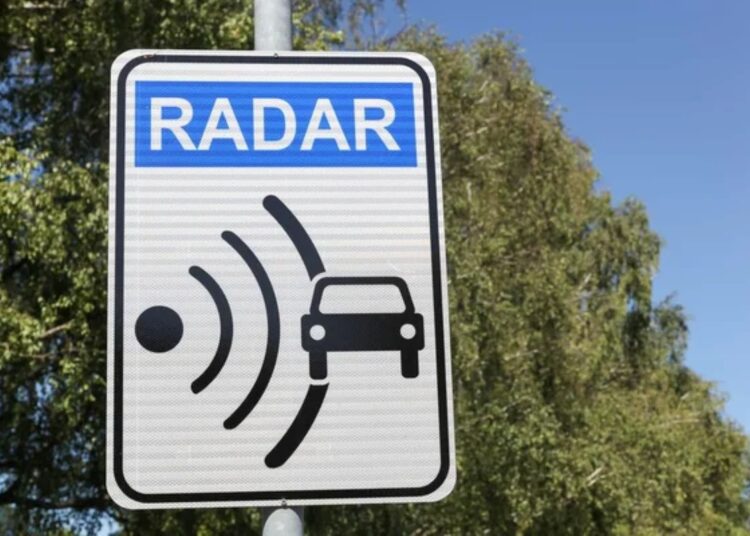 Placa de radar de trânsito indicando fiscalização de velocidade