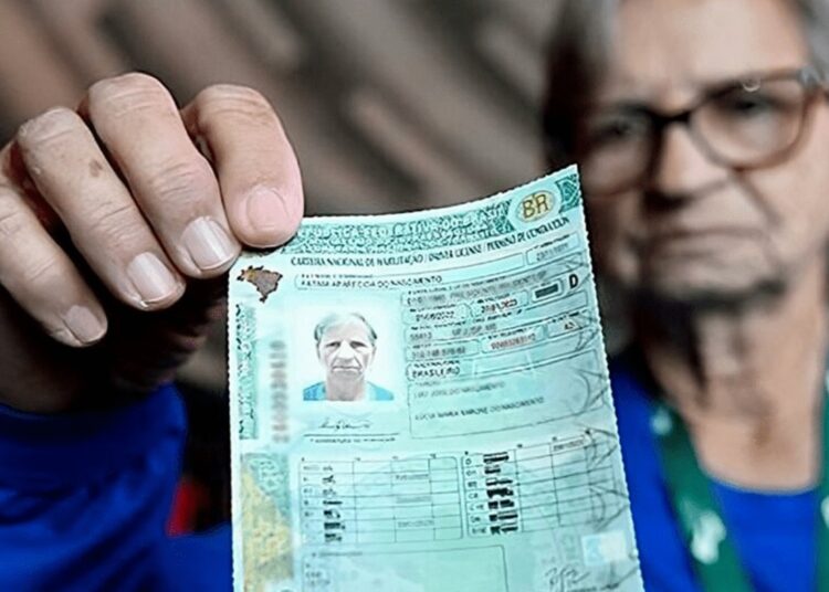 Pessoa idosa segurando a Carteira Nacional de Habilitação (CNH) em destaque