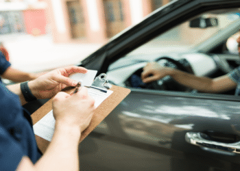 Agente de trânsito aplicando multa a motorista parado em fiscalização