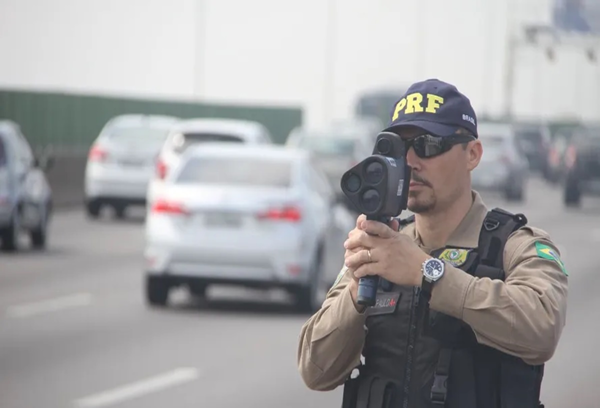 Agente da PRF opera radar móvel em rodovia para controle de velocidade