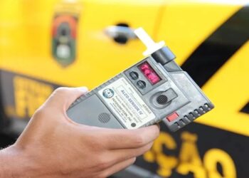 Agente segura bafômetro durante operação de fiscalização contra infrações em rodovia