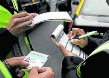 Agentes de trânsito aplicando multas, preenchendo autuações e fiscalizando documento do condutor