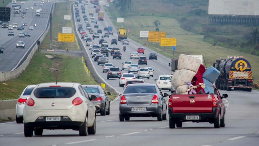 Trânsito intenso em rodovia com veículos trafegando e ultrapassando pela direita