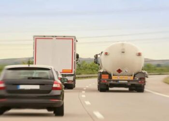 Caminhão em ato de ultrapassar pela direita em rodovia com tráfego intenso