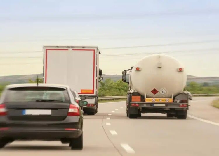 Caminhão em ato de ultrapassar pela direita em rodovia com tráfego intenso