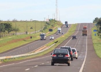 Rodovia com pista dupla e veículos transitando em diferentes faixas, incluindo carros e caminhões.