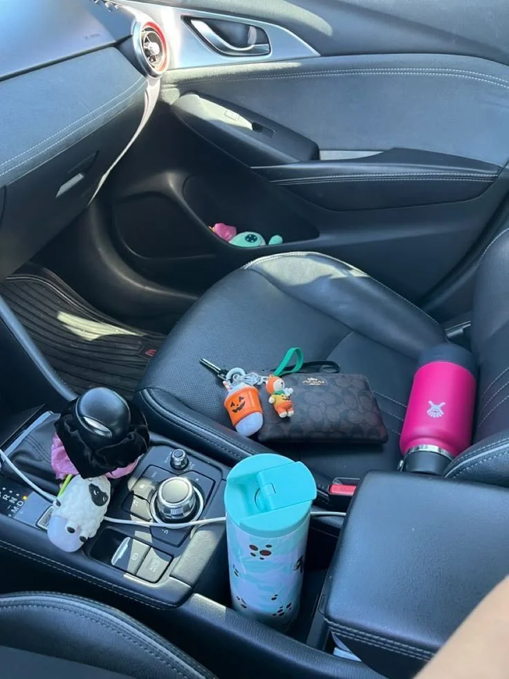 Interior de carro mostrando objetos pessoais soltos, como garrafas e chaves, que podem representar riscos à segurança.