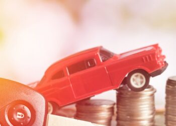 Imagem mostrando um carro em miniatura sobre pilhas de moedas, representando o uso do FGTS para comprar um veículo.