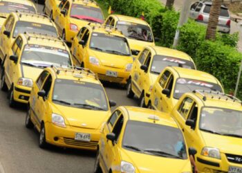 Imagem de uma fila de táxis amarelos.