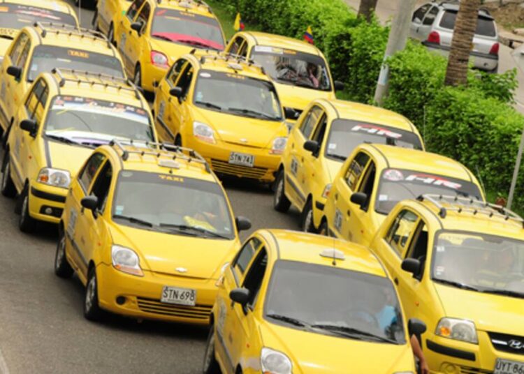 Imagem de uma fila de táxis amarelos.