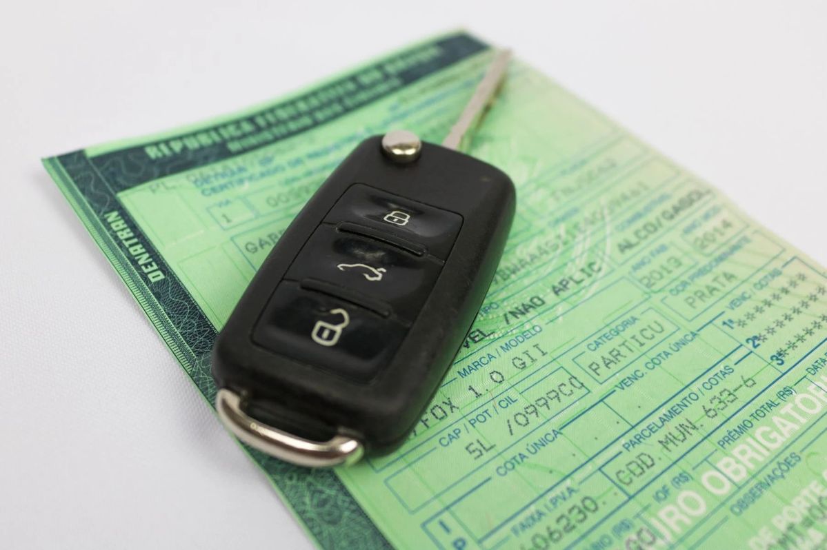 Chave de carro em cima de um documento de veículo com a sigla DENATRAN e o nome IPVA.