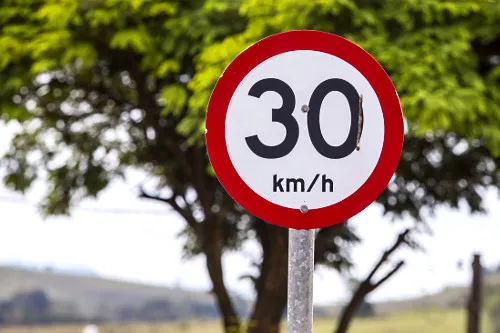 Placa de trânsito indicando limite de velocidade de 30 km/h.