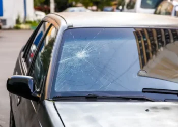 Vidro trincado de carro mostrando rachaduras, tema sobre multa por vidro trincado de acordo com a lei de trânsito 2025.