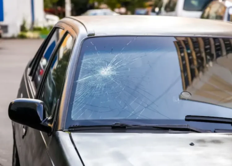 Vidro trincado de carro mostrando rachaduras, tema sobre multa por vidro trincado de acordo com a lei de trânsito 2025.