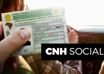 Mão segurando carteira de motorista no interior de veículo, destaque para CNH Social 2026.