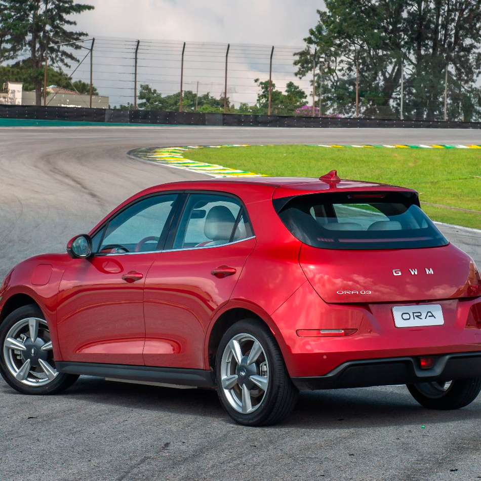 Carro GWM Ora 03 Skin BEV48 vermelho contorna curva em pista de corrida iluminada.