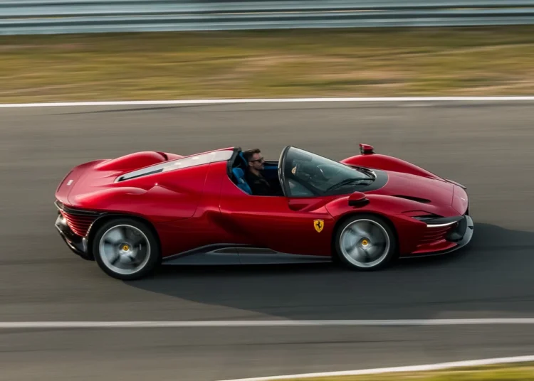 Carro esportivo conversível vermelho com motorista em alta velocidade na pista de corrida