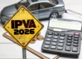 Placa amarela com texto IPVA 2026, calculadora, moedas e miniatura de carro ao fundo