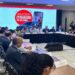 Autoridades e representantes de entregadores debatem propostas em mesa redonda, tela exibe tema da regulamentação