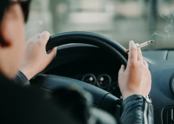 Motorista conduz veículo enquanto segura cigarro aceso com a mão direita no volante