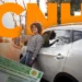 Mulher sorrindo segura chave do carro automático ao lado de veículo branco com CNH em primeiro plano