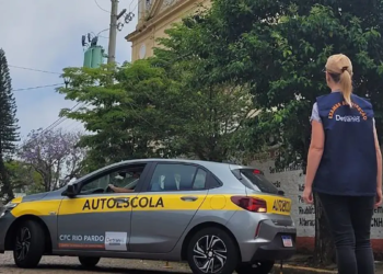 Examinadora do Detran RS observa veículo de autoescola CFC Rio Pardo durante prova prática em via urbana