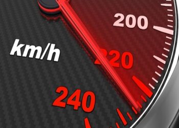 Velocímetro automotivo com ponteiro vermelho indicando acima de 200 km/h em painel com textura de fibra de carbono