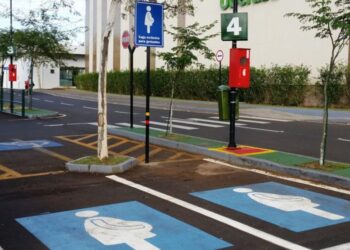 Estacionamento com vagas reservadas para gestantes sinalizadas em azul, placa vertical e símbolo no piso