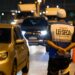 Agente com colete "Operação Lei Seca" observa veículos em blitz noturna com cones laranjas no Rio de Janeiro