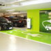 Dois carros elétricos conectados a carregador EVlink em vagas verdes com sinalização para veículos elétricos