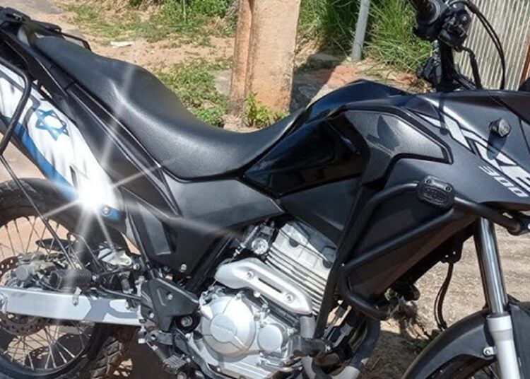 Honda XRE 300 preta estacionada em ambiente externo com bagageiro lateral metálico e motor monocilíndrico prateado