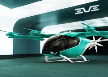 Carro voador eVTOL da Eve Air Mobility verde-água e preto em vertiporto moderno com logo EVE ao fundo.