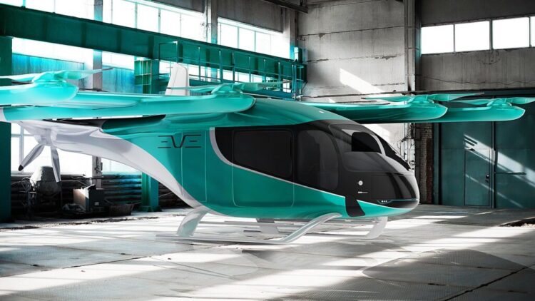 Aeronave eVTOL Eve turquesa com 8 rotores e hélice traseira em hangar industrial, design lift & cruise.