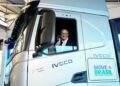 Geraldo Alckmin sorrindo faz sinal positivo na cabine de caminhão branco IVECO S-Way com logo Move Brasil