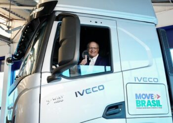 Geraldo Alckmin sorrindo faz sinal positivo na cabine de caminhão branco IVECO S-Way com logo Move Brasil