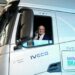 Geraldo Alckmin sorrindo faz sinal positivo na cabine de caminhão branco IVECO S-Way com logo Move Brasil