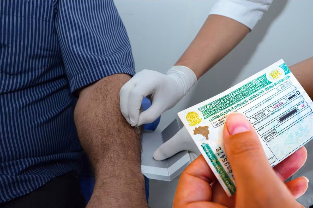 Profissional de saúde com luvas coleta sangue de braço enquanto mão segura CNH brasileira categoria B