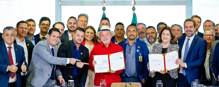 Presidente Lula com camisa vermelha e chapéu ao centro, cercado por autoridades durante lançamento do Move Aplicativos