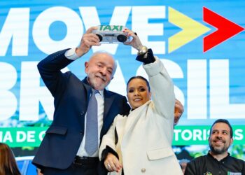 Presidente Lula e dirigente sindical seguram luminoso de táxi no evento Move Brasil em São Paulo