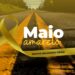 Laço amarelo sobre rodovia asfaltada com faixas contínuas e texto 'Maio Amarelo: Juntos Salvamos Vidas'.
