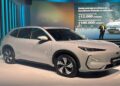 SUV Geely EX5 branco em destaque durante lançamento com painel digital ao fundo
