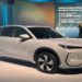 SUV Geely EX5 branco em destaque durante lançamento com painel digital ao fundo